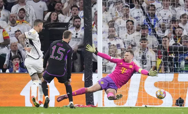 Real Madrid's Joselu, left, scores his side's opening goal in front of Bayern's goalkeeper Manuel Neuer, right, during the Champions League semifinal second leg soccer match between Real Madrid and Bayern Munich at the Santiago Bernabeu stadium in Madrid, Spain, Wednesday, May 8, 2024. (AP Photo/Manu Fernandez)