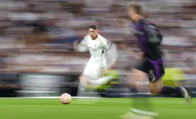Real Madrid's Federico Valverde runs with the ball during the Champions League semifinal second leg soccer match between Real Madrid and Bayern Munich at the Santiago Bernabeu stadium in Madrid, Spain, Wednesday, May 8, 2024. (AP Photo/Manu Fernandez)