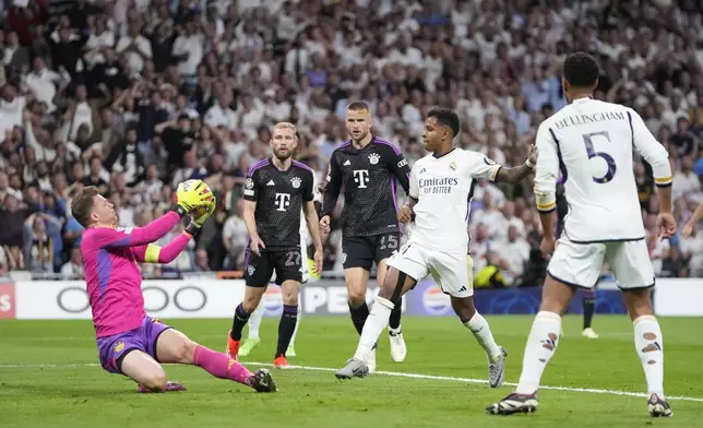Bayern's goalkeeper Manuel Neuer, left, makes a save in front Real Madrid's Rodrygo, second right, during the Champions League semifinal second leg soccer match between Real Madrid and Bayern Munich at the Santiago Bernabeu stadium in Madrid, Spain, Wednesday, May 8, 2024. (AP Photo/Manu Fernandez)