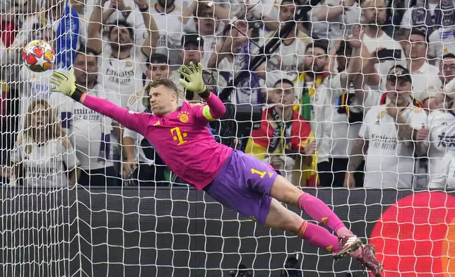 Bayern's goalkeeper Manuel Neuer dives to make a save during the Champions League semifinal second leg soccer match between Real Madrid and Bayern Munich at the Santiago Bernabeu stadium in Madrid, Spain, Wednesday, May 8, 2024. (AP Photo/Manu Fernandez)