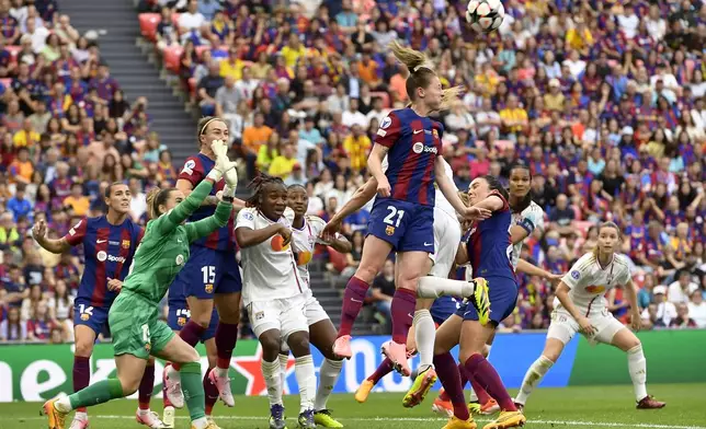 Barcelona's Keira Walsh, center, leaps to clear the ball away from the box during the women's Champions League final soccer match between FC Barcelona and Olympique Lyonnais at the San Mames stadium in Bilbao, Spain, Saturday, May 25, 2024. (AP Photo/Alvaro Barrientos)