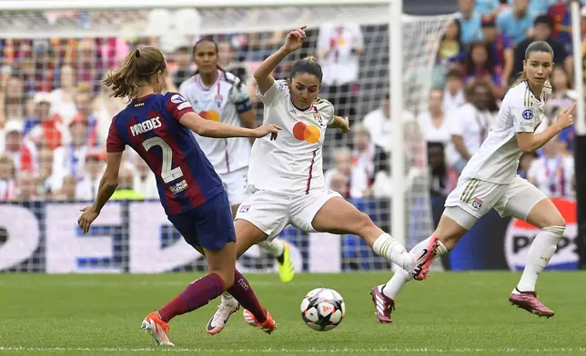 Lyon's Delphine Cascarino tries to block a shot from Barcelona's Irene Paredes, left, during the women's Champions League final soccer match between FC Barcelona and Olympique Lyonnais at the San Mames stadium in Bilbao, Spain, Saturday, May 25, 2024. (AP Photo/Alvaro Barrientos)