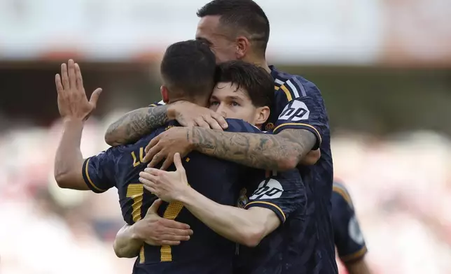 Real Madrid's Fran Garcia, center, is congratulated after scoring his side's opening goal during a Spanish La Liga soccer match between Granada FC and Real Madrid at Los Carmanes stadium in Granada, Spain, Saturday, May 11, 2024. (AP Photo/Fermin Rodriguez)