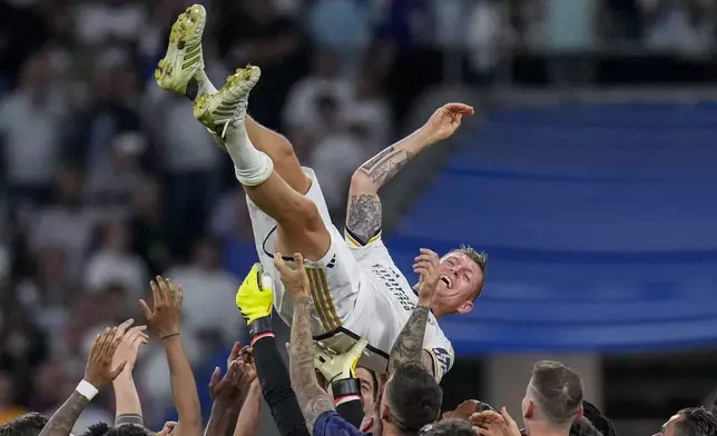 Real Madrid's Toni Kroos is lifted in the air by his teammates during a Spanish La Liga soccer match between Real Madrid and Betis at the Santiago Bernabeu stadium in Madrid, Spain, Saturday, May 25, 2024. Real Madrid said the 34-year-old German international "has decided to bring an end to his time as a professional footballer following Euro 2024".(AP Photo/Manu Fernandez)