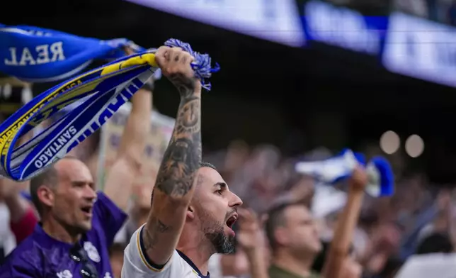Real Madrid's supporters cheer their team during the the Spanish La Liga soccer match between Real Madrid and Cadiz at the Santiago Bernabeu stadium in Madrid, Spain, Saturday, May 4, 2024. (AP Photo/Manu Fernandez)