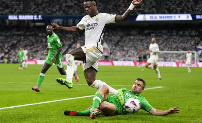 Real Madrid's Vinicius Junior, top, vies for the ball, with Betis' Sokratis Papastathopoulos during a Spanish La Liga soccer match between Real Madrid and Betis at the Santiago Bernabeu stadium in Madrid, Spain, Saturday, May 25, 2024. (AP Photo/Manu Fernandez)