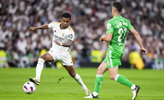 Real Madrid's Rodrygo, left, fights for the ball with Betis' Marc Roca during a Spanish La Liga soccer match between Real Madrid and Betis at the Santiago Bernabeu stadium in Madrid, Spain, Saturday, May 25, 2024. (AP Photo/Manu Fernandez)