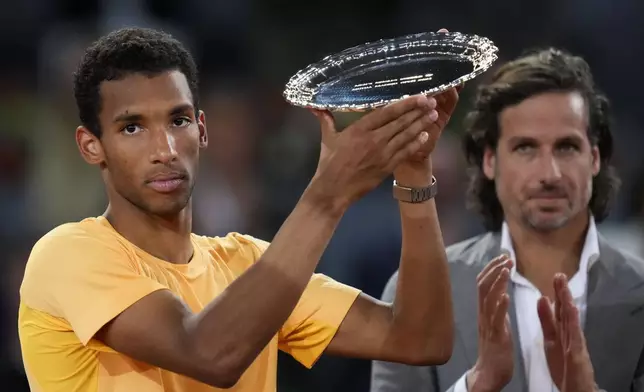 Felix Auger-Aliassime, of Canada, holds his trophy after loosing against Andrey Rublev, of Russia, in he Madrid Open men's final match in Madrid, Spain, Sunday, May 5, 2024. (AP Photo/Manu Fernandez)