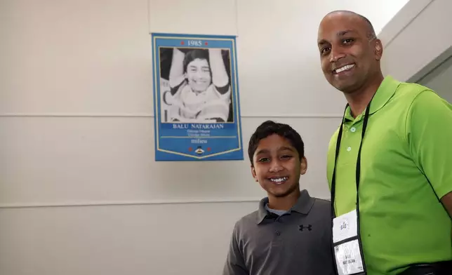 FILE - Dr. Balu Natarajan, right, from Hinsdale, Ill., poses for a photograph with his son Atman Balakrishnan, 12, at the Scripps National Spelling Bee, Tuesday, May 29, 2018, in Oxon Hill, Md. Since 1999, 28 of the last 34 Scripps National Spelling bee champions have been Indian American. And most of those winners are the offspring of parents who arrived in the United States on student or work visas. The experiences of first-generation Indian Americans and their spelling bee champion children illustrate the economic success and cultural impact of the nation’s second-largest immigrant group. (AP Photo/Alex Brandon, File)