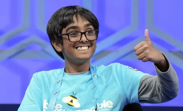 Faizan Zaki, 12, of Allen, Texas ., gestures to his family after spelling his word correctly in the finals of the Scripps National Spelling Bee, in Oxon Hill, Md., Thursday, May 30, 2024. (AP Photo/Mariam Zuhaib)