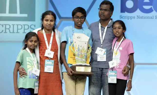 Bruhat Soma, 12, of Tampa, Fla., stands on stage with his family after winning the Scripps National Spelling Bee, in Oxon Hill, Md., Thursday, May 30, 2024. (AP Photo/Mariam Zuhaib)