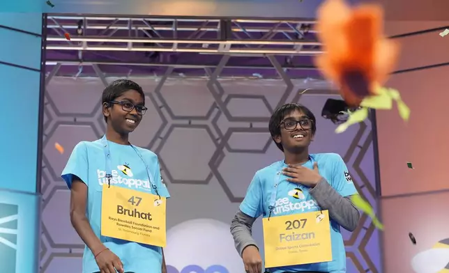 As confetti falls Bruhat Soma, 12, of Tampa, Fla., left, smiles after winning the Scripps National Spelling Bee, in Oxon Hill, Md., Thursday, May 30, 2024, as Faizan Zaki, 12, of Allen, Texas, stands next to him on stage. (AP Photo/Jacquelyn Martin)