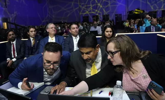 Officials confer during a break in competition in the finals of the Scripps National Spelling Bee, in Oxon Hill, Md., Thursday, May 30, 2024. (AP Photo/Nathan Howard)