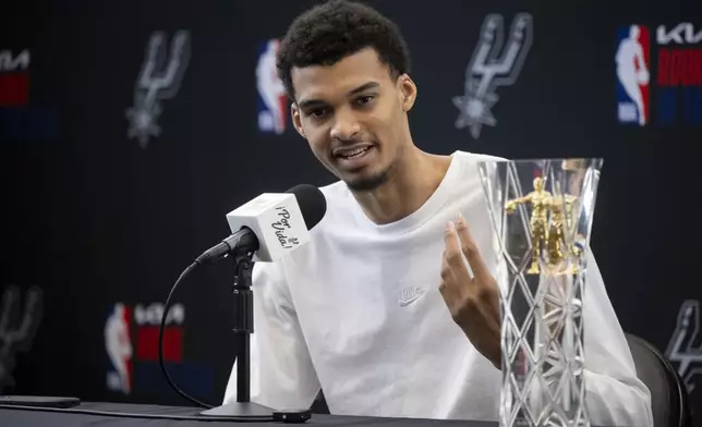 San Antonio Spurs' Victor Wembanyama speaks to media after receiving his 2023-24 NBA Rookie of the Year trophy during an NBA basketball news conference, Saturday, May 11, 2024, in San Antonio. (AP Photo/Darren Abate)