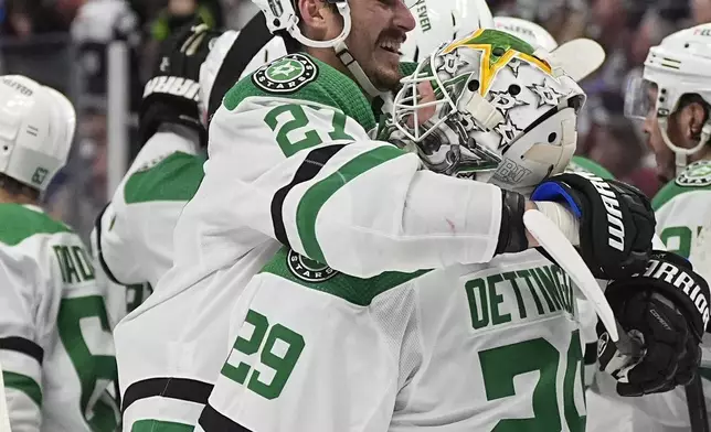 Dallas Stars left wing Mason Marchment, left, hugs goaltender Jake Oettinger after Game 6 of an NHL hockey playoff series Friday, May 17, 2024, in Denver. (AP Photo/David Zalubowski)