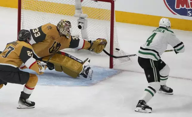 Dallas Stars defenseman Miro Heiskanen (4) attempts a shot on Vegas Golden Knights goaltender Adin Hill (33) during the second period in Game 6 of an NHL hockey Stanley Cup first-round playoff series Friday, May 3, 2024, in Las Vegas. (AP Photo/John Locher)