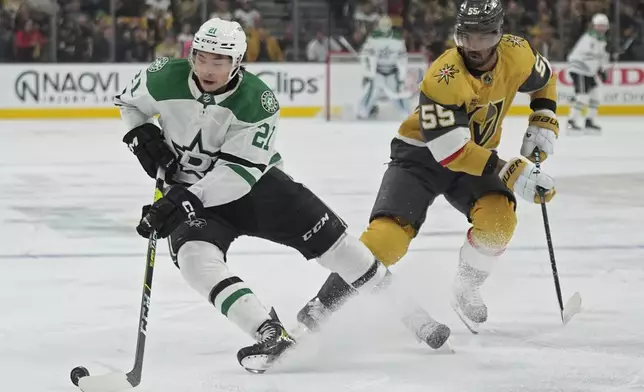 Dallas Stars left wing Jason Robertson (21) and Vegas Golden Knights right wing Keegan Kolesar (55) vie for the puck during the first period in Game 6 of an NHL hockey Stanley Cup first-round playoff series Friday, May 3, 2024, in Las Vegas. (AP Photo/John Locher)