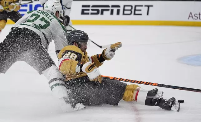 Dallas Stars defenseman Esa Lindell (23) knocks down Vegas Golden Knights left wing William Carrier (28) during the second period in Game 6 of an NHL hockey Stanley Cup first-round playoff series Friday, May 3, 2024, in Las Vegas. (AP Photo/John Locher)