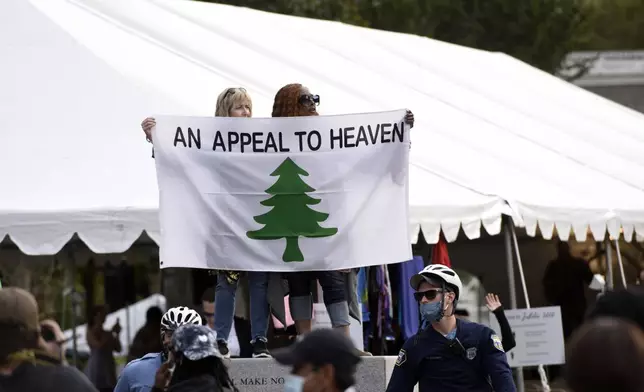 FILE - People carry an "Appeal To Heaven" flag as they gather at Independence Mall to support President Donald Trump during a visit to the National Constitution Center to participate in the ABC News town hall, Sept. 15, 2020, in Philadelphia. Supreme Court Justice Samuel Alito is embroiled in a second flag controversy, this time over the “Appeal to Heaven” flag, a banner that in recent years has come to symbolize Christian nationalism and the false claim that the 2020 presidential election was stolen. The flag was seen outside his New Jersey beach home last summer. (AP Photo/Michael Perez, File)