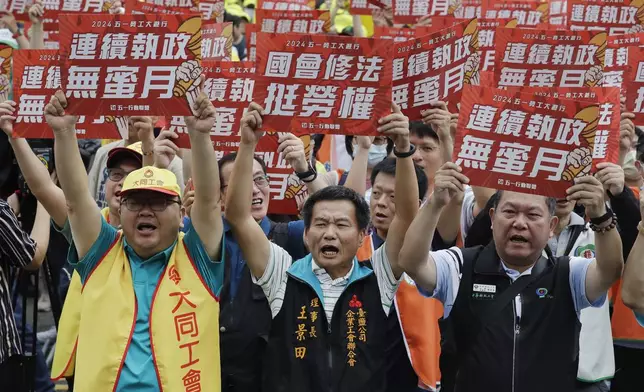 Taiwanese workers hold slogans reading "Congress amended the law to support workers' rights" and ''The regime has no honeymoon'' during a May Day rally in Taipei, Taiwan, Wednesday, May 1, 2024. Thousands of protesters from different labor groups protest on the street to ask for labor rights and interests. (AP Photo/Chiang Ying-ying)