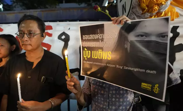 Thai activists hold a portrait of Netiporn Sanesangkhom, a member of the activist group Thaluwang, known for their bold and aggressive campaigns demanding reform of the monarchy and abolition of the law that makes it illegal to defame members of the royal family outside of Criminal court in Bangkok, Thailand, Tuesday, May 14, 2024. Netiporn who went on a hunger strike after being jailed for her involvement in protests calling for reform of the country's monarchy system died Tuesday in a prison hospital, officials said. (AP Photo/Sakchai Lalit)