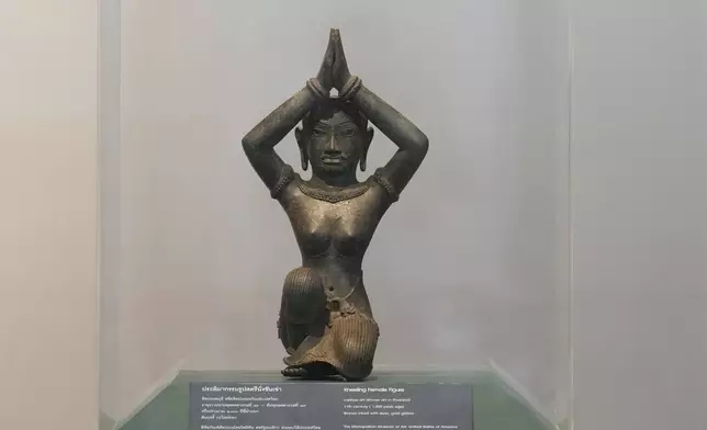 The ancient bronze kneeling woman sculpture is displayed during a repatriation ceremony at National Museum in Bangkok, Thailand, Tuesday, May 21, 2024. Thailand's National Museum hosted a welcome-home ceremony for two ancient statues that were illegally trafficked from Thailand by a British collector of antiquities and were returned from the collection of New York’s Metropolitan Museum of Art. The objects, a tall bronze figure called the “Standing Shiva” or the “Golden Boy” and a smaller sculpture called “Kneeling Female," are thought to be around 1,000 years old. (AP Photo/Sakchai Lalit)