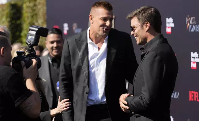 Tom Brady, right, mingles with his former NFL teammate Rob Gronkowski at "The Greatest Roast of All Time: Tom Brady" at the Kia Forum, Sunday, May 5, 2024, in Inglewood, Calif. (AP Photo/Chris Pizzello)
