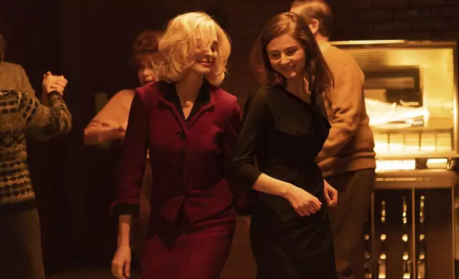 This image released by Neon shows Anne Hathaway, left, and Thomasin McKenzie in a scene from "Eileen." (Jeong Park/Neon via AP)