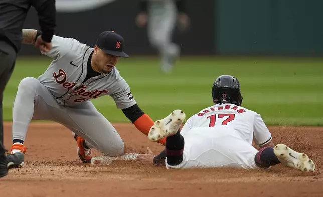 Detroit Tigers shortstop Javier Báez, left, tags out Cleveland Guardians' Will Brennan (17) at second base on an attempted steal in the fourth inning of a baseball game Monday, May 6, 2024, in Cleveland. (AP Photo/Sue Ogrocki)