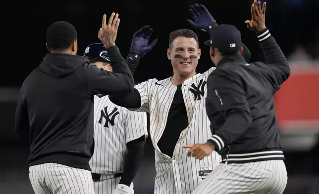 New York Yankees' Anthony Rizzo, center, celebrates with teammates after hitting a walk-off RBI single during the ninth inning of a baseball game against the Detroit Tigers, Friday, May 3, 2024, in New York. The Yankees won 2-1. (AP Photo/Frank Franklin II)