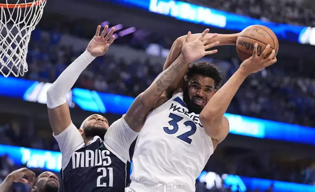 Minnesota Timberwolves center Karl-Anthony Towns (32) grabs a rebound over Dallas Mavericks center Daniel Gafford (21) during the second half in Game 3 of the NBA basketball Western Conference finals, Sunday, May 26, 2024, in Dallas. (AP Photo/Julio Cortez)