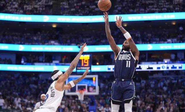 Dallas Mavericks guard Kyrie Irving (11) shoots over Minnesota Timberwolves guard Nickeil Alexander-Walker (9) during the second half in Game 3 of the NBA basketball Western Conference finals, Sunday, May 26, 2024, in Dallas. (AP Photo/Julio Cortez)