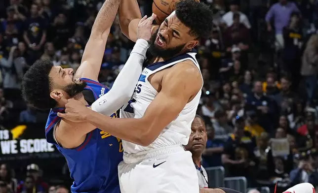 Denver Nuggets guard Jamal Murray, left, fights for control of the ball with Minnesota Timberwolves center Karl-Anthony Towns, front right, in the first half of Game 1 of an NBA basketball second-round playoff series Saturday, May 4, 2024, in Denver. (AP Photo/David Zalubowski)