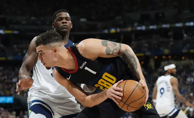 Denver Nuggets forward Michael Porter Jr., front, is defended by Minnesota Timberwolves guard Anthony Edwards during the first half of Game 5 of an NBA basketball second-round playoff series Tuesday, May 14, 2024, in Denver (AP Photo/David Zalubowski)