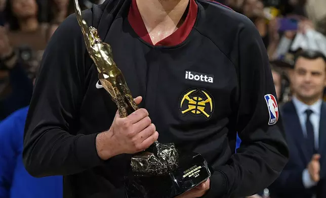 Denver Nuggets center Nikola Jokic holds his NBA basketball MVP trophy before Game 5 of the team's second-round playoff series against the Minnesota Timberwolves on Tuesday, May 14, 2024, in Denver (AP Photo/David Zalubowski)