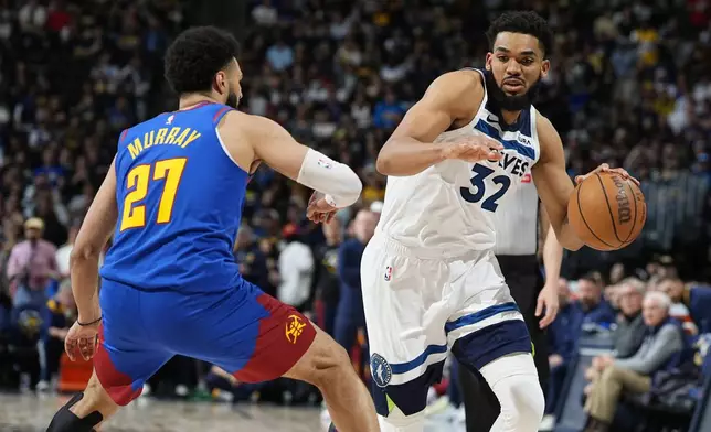 Minnesota Timberwolves center Karl-Anthony Towns, right, drives past Denver Nuggets guard Jamal Murray, left, in the second half of Game 1 of an NBA basketball second-round playoff series Saturday, May 4, 2024, in Denver. (AP Photo/David Zalubowski)