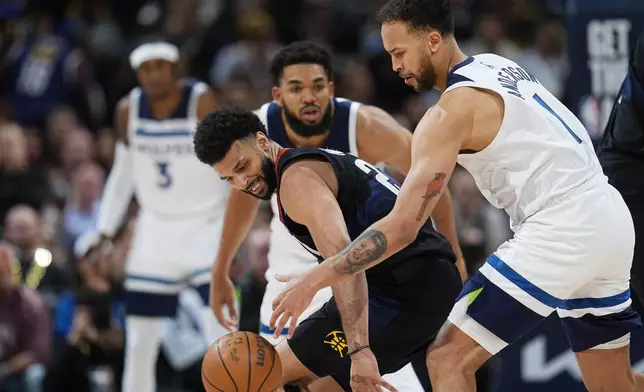 Denver Nuggets guard Jamal Murray, front left, loses control of the ball as Minnesota Timberwolves forward Kyle Anderson, front right, and center Karl-Anthony Towns defend in the second half of Game 2 of an NBA basketball second-round playoff series, Monday, May 6, 2024, in Denver. (AP Photo/David Zalubowski)