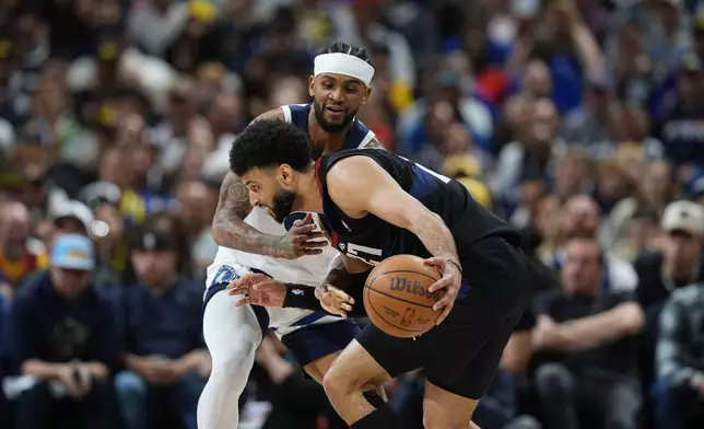 Denver Nuggets guard Jamal Murray, front, looks to drive past Minnesota Timberwolves guard Nickeil Alexander-Walker in the second half of Game 2 of an NBA basketball second-round playoff series, Monday, May 6, 2024, in Denver. (AP Photo/David Zalubowski)