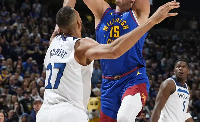 Denver Nuggets center Nikola Jokic, right, goes up for a basket over Minnesota Timberwolves center Rudy Gobert in the first half of Game 1 of an NBA basketball second-round playoff series Saturday, May 4, 2024, in Denver. (AP Photo/David Zalubowski)