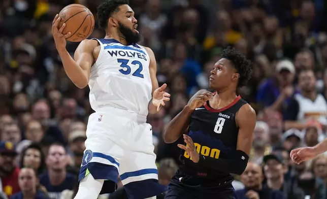 Minnesota Timberwolves center Karl-Anthony Towns, left, fields a pass next to Denver Nuggets forward Peyton Watson during the first half of Game 5 of an NBA basketball second-round playoff series Tuesday, May 14, 2024, in Denver (AP Photo/David Zalubowski)
