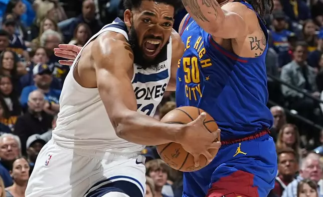 Minnesota Timberwolves center Karl-Anthony Towns, left, drives past Denver Nuggets forward Aaron Gordon, right, in the second half of Game 1 of an NBA basketball second-round playoff series Saturday, May 4, 2024, in Denver. (AP Photo/David Zalubowski)