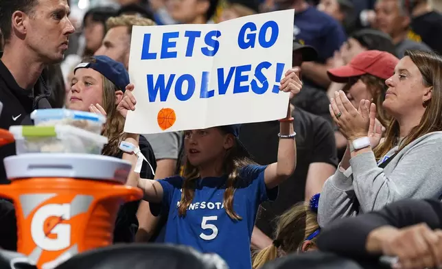 A Minnesota Timberwolves fan holds up a sign in the second half of Game 1 of an NBA basketball second-round playoff series against the Denver Nuggets, Saturday, May 4, 2024, in Denver. (AP Photo/David Zalubowski)