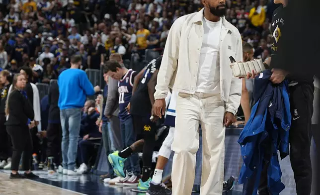 Injured Minnesota Timberwolves guard Mike Conley walks near the bench during the first half of Game 5 of the team's NBA basketball second-round playoff series against the Denver Nuggets on Tuesday, May 14, 2024, in Denver (AP Photo/David Zalubowski)