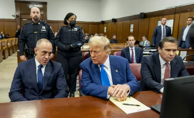 Former President Donald Trump, center, talks with defense attorney Emil Bove, left, before the start of trial at Manhattan criminal court, Friday, May 3, 2024 in New York. (Mark Peterson/Pool Photo via AP)
