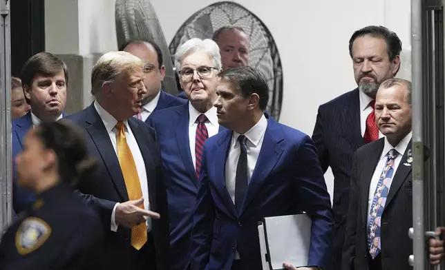 Former President Donald Trump speaks with his attorney Todd Blanche during in his trial, Tuesday, May 21, 2024, in Manhattan Criminal Court in New York. Looking on, from left are. U.S. Rep. Dale Strong, R-Ala. Texas Lt. Gov. Dan Patrick, radio host Sebastian Gorka and U.S. Rep. Troy Nehls, R-Texas. (Curtis Means/Dailymail.com via AP, Pool)
