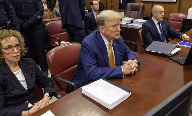 Former President Donald Trump, center, sits at the defense table with his attorneys Susan Necheles, left, and Emil Bove in Manhattan criminal court, Tuesday, May 7, 2024, in New York. (Sarah Yenesel/Pool Photo via AP)