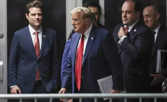 Former President Donald Trump, center, walks by Rep. Matt Gaetz, left, R-Fla., outside the courtroom after the day's proceedings in his trial Thursday, May 16, 2024, in New York. Trump's adviser Boris Epshteyn, and attorney Emil Bove, right, follow behind him. (Mike Segar/Pool Photo via AP)