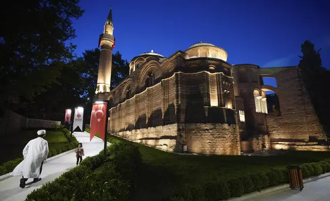 A Muslim cleric walks along a former Byzantine church which formally opened as a mosque, in Istanbul, Turkey, Monday, May 6, 2024. Turkish President Recep Tayyip Erdogan formally opened a former Byzantine church in Istanbul as a mosque on Monday, four years after his government had designated it a Muslim house of prayer, despite criticism from neighboring Greece. (AP Photo/Emrah Gurel)