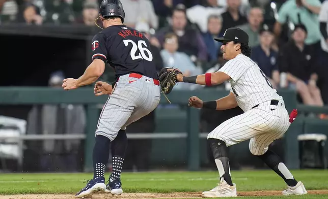 Minnesota Twins right fielder Max Kepler, left, gets caught between bases by Chicago White Sox catcher Martín Maldonado and is tagged out by third baseman Nicky Lopez during the sixth inning of a baseball game Tuesday, April 30, 2024, in Chicago. (AP Photo/Erin Hooley)