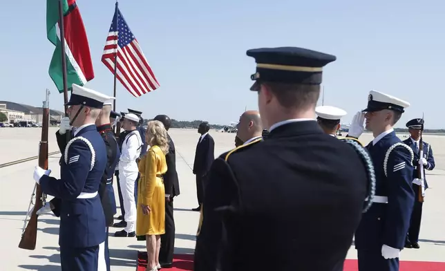 First lady Jill Biden stands, center yellow, stands with Kenya's President William Ruto during the American national anthem at Andrews Air Force Base, Md., Wednesday, May 22, 2024, during President Ruto's state visit to the United States. (AP Photo/Luis M. Alvarez)